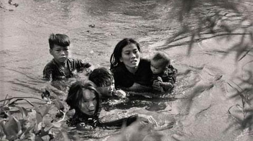 Một bà mẹ Việt Nam cùng với con vượt sông để tránh bom của máy bay Mỹ, Quy Nhơn năm 1965